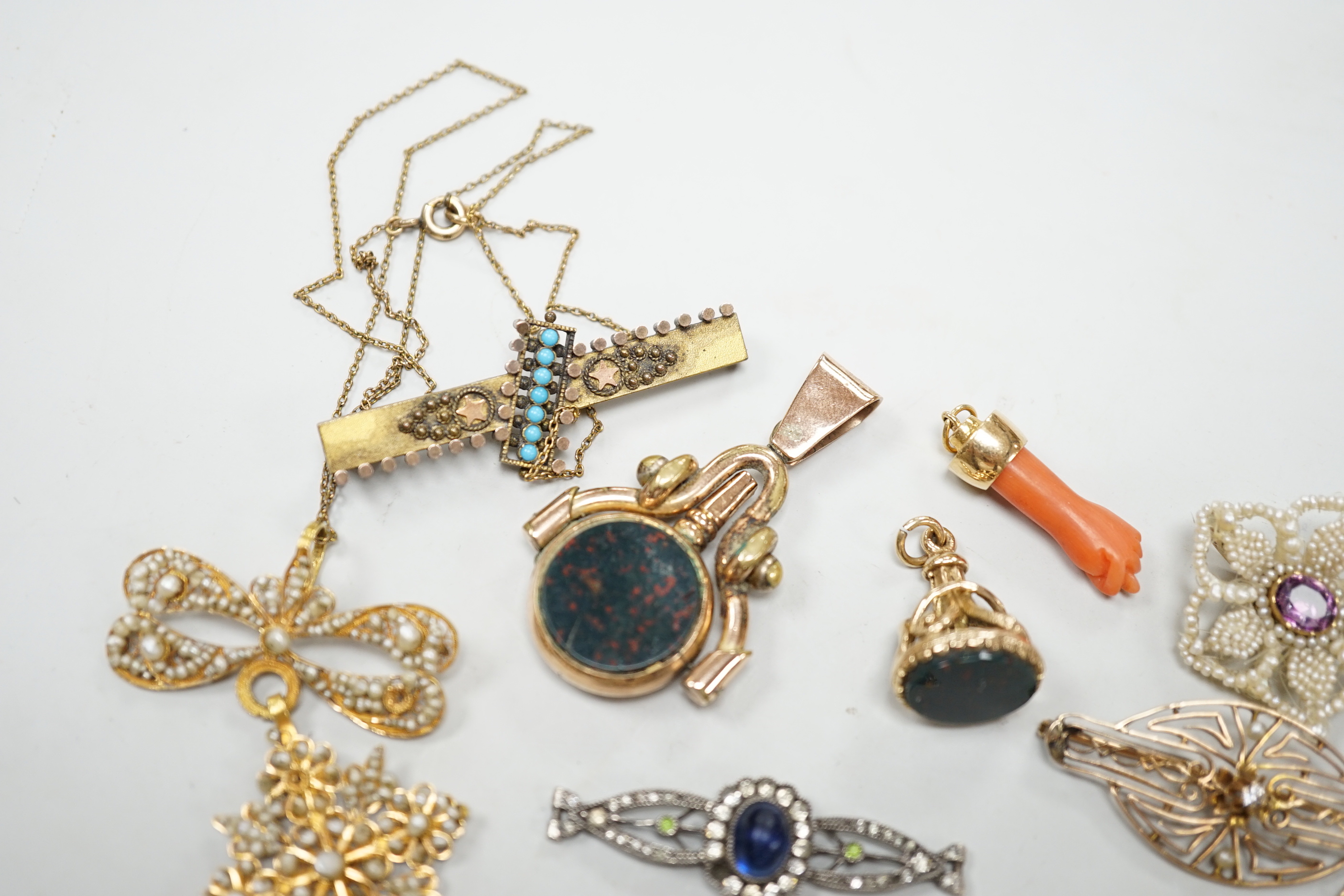 A small group of antique and later jewellery, including 9ct gold and bloodstone fob seal, a 1930's yellow metal and seed pearl set key brooch, 14k and black enamel brooch, spinning fob pendant, coral hand charm, 10k and
